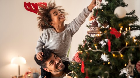 Ouder met kind bij kerstboom